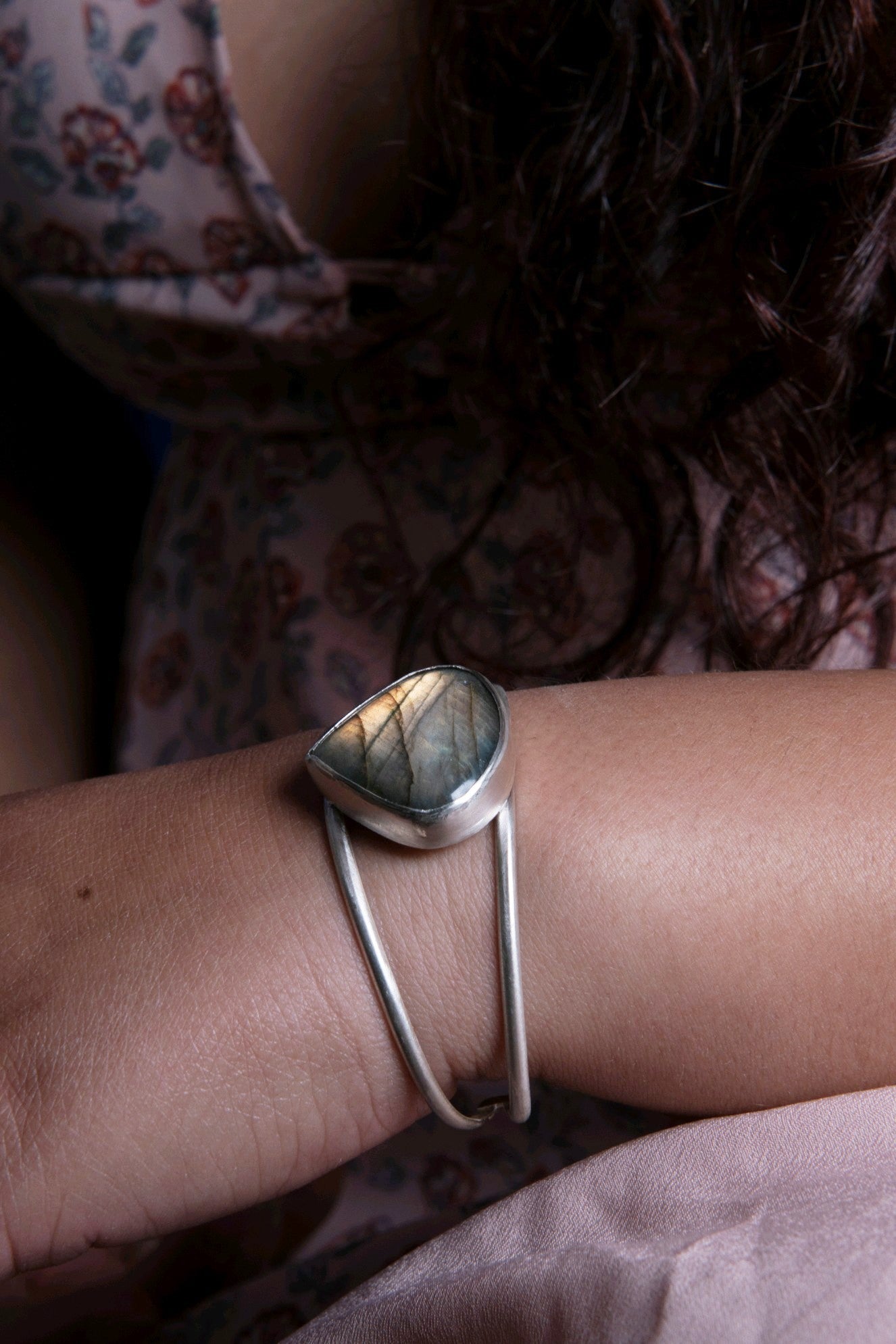 sterling silver large teardrop labradorite with yellow orange flash just starting to hit the light gray stone as it's shifted to the light